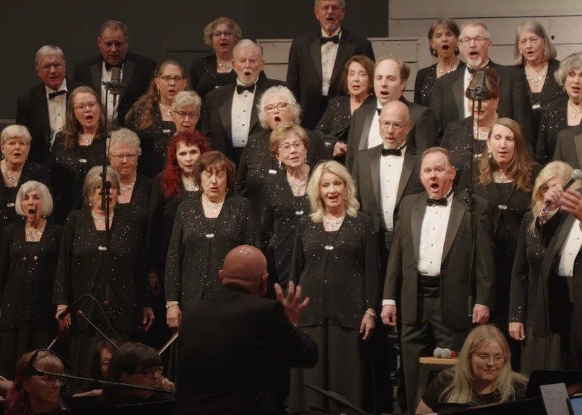 a close up of the choir and orchestra performing